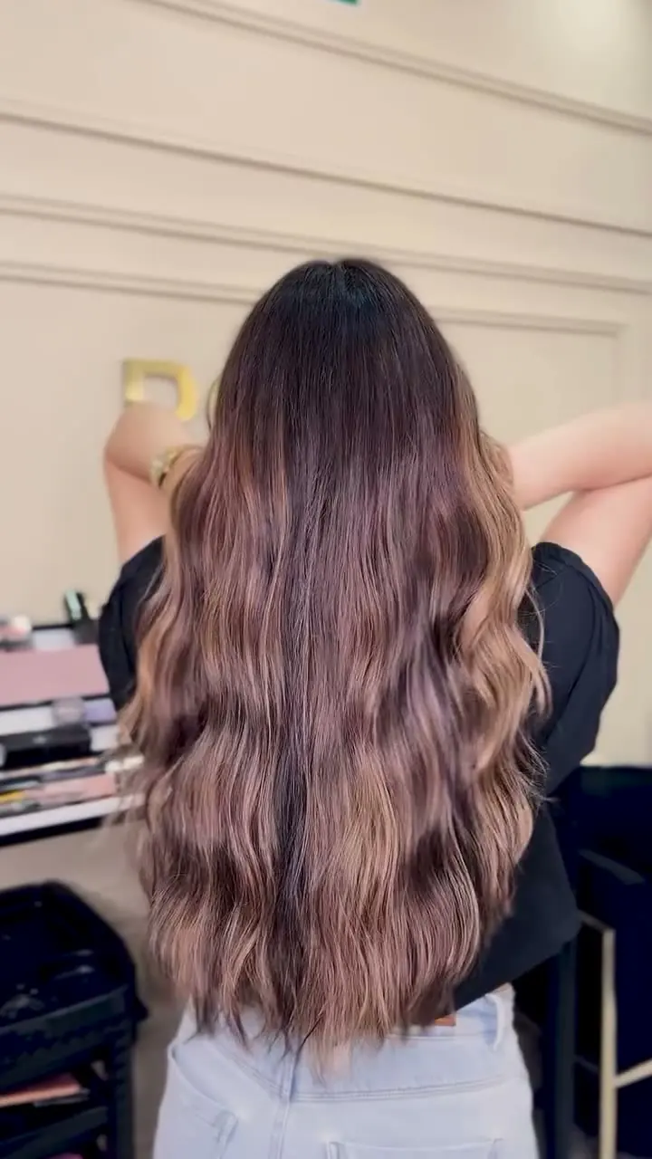 Cabello largo con balayage en tonos miel, visto de espaldas en el salón